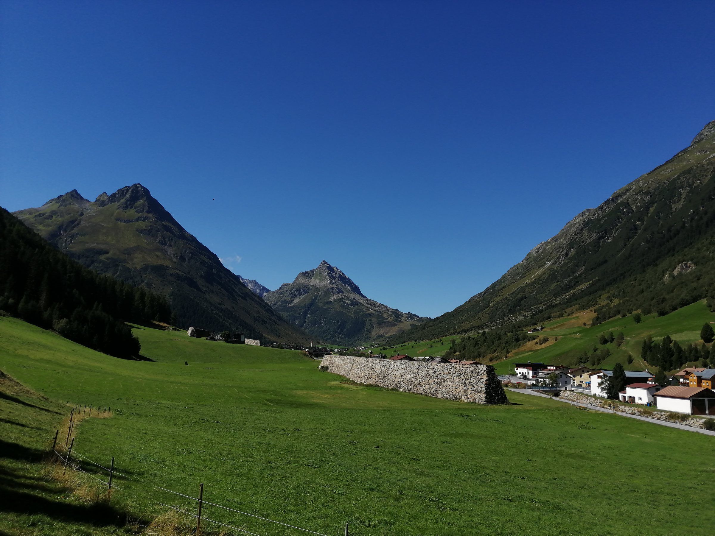 Galtür im Sommer mit grünen Wiesen und Blick auf die Berge