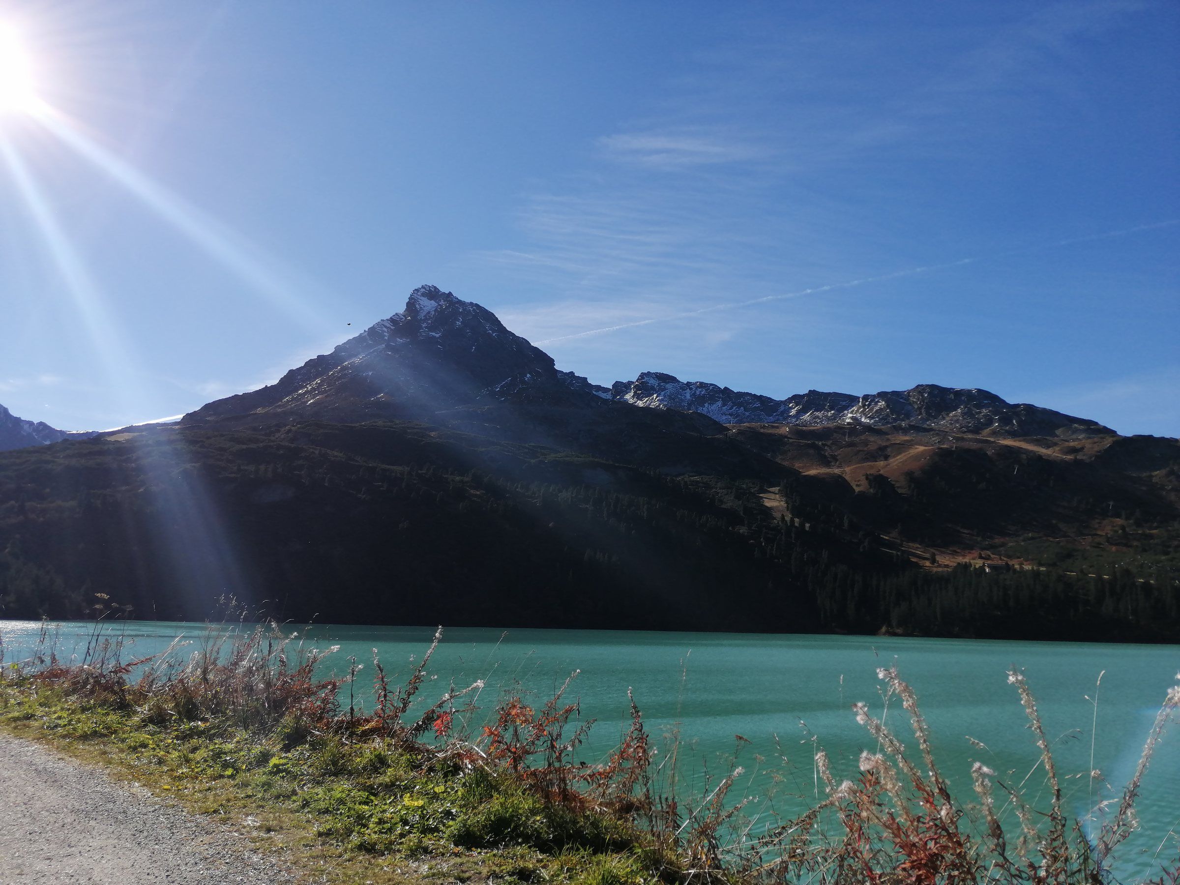 Der türkisfarbene Kops-Stausee mit Bergpanorama im Herbst
